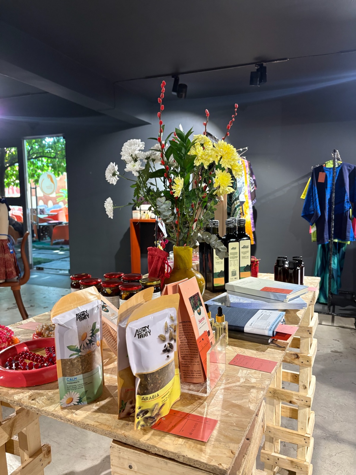 Vendor table with flowers, pantry goods and books
